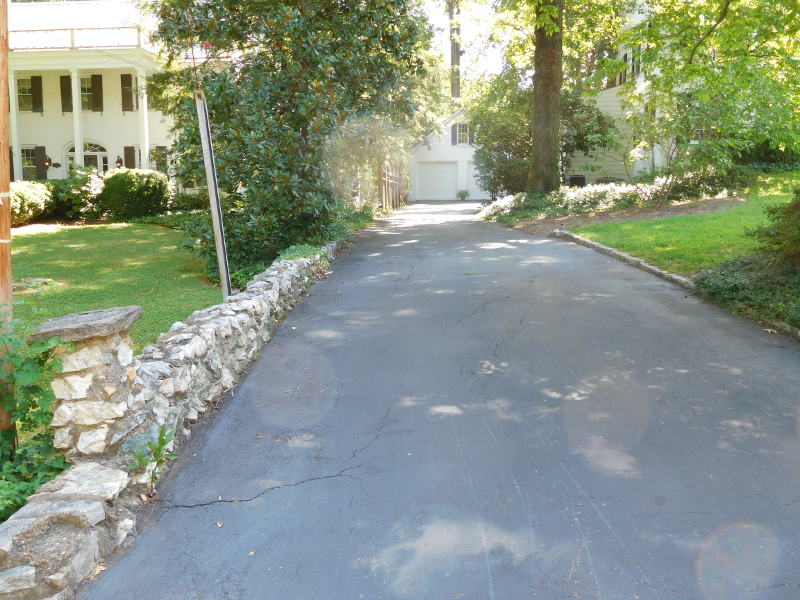 driveway of 12 Marshall Street in South Boston, with garage at end and the home of the Wall family on the other side of the stone wall